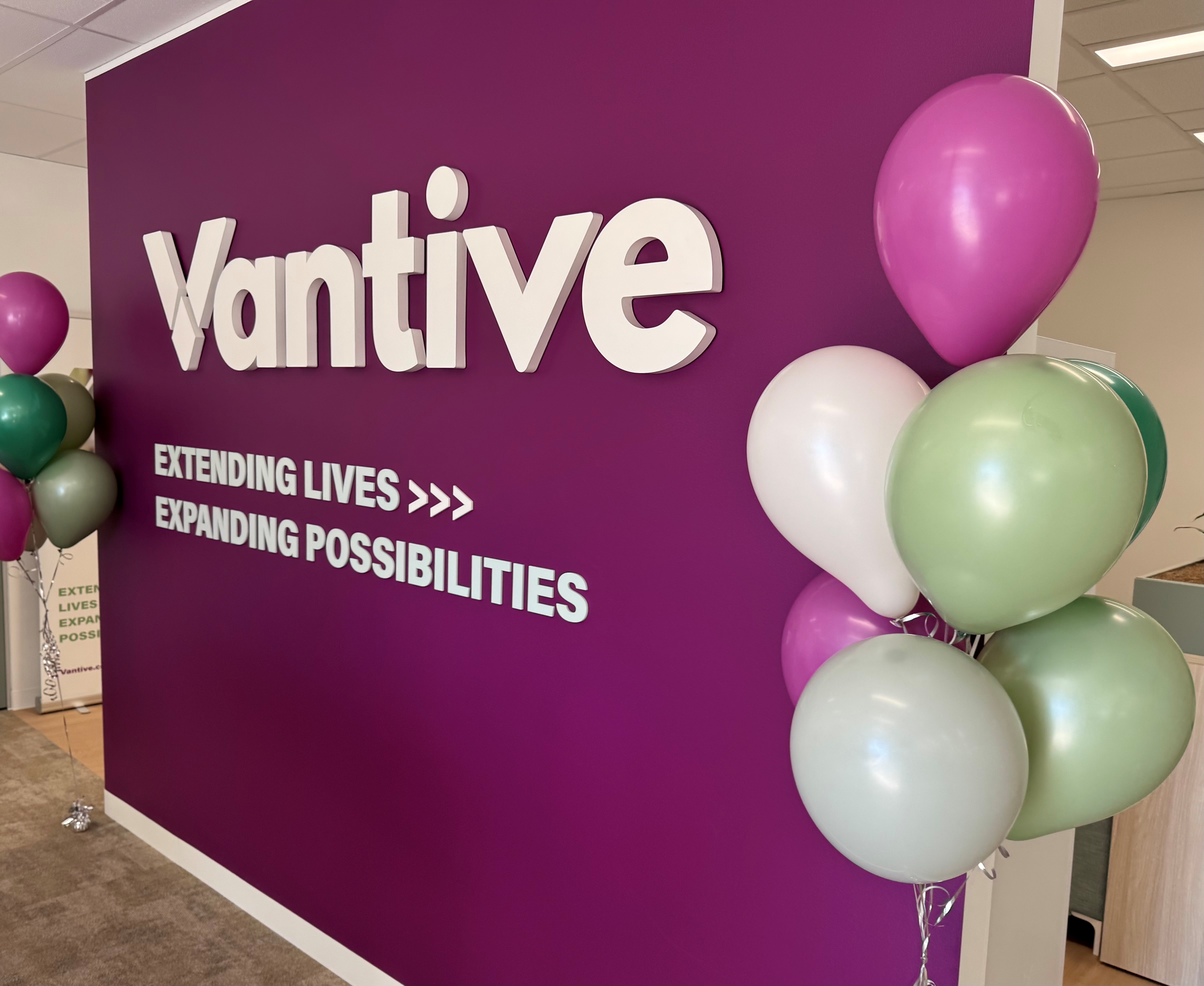 Vantive logo and “Extending Lives, Expanding Possibilities” displayed on a wall decorated with balloons.