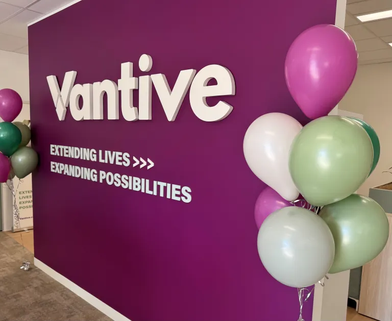 Vantive logo and “Extending Lives, Expanding Possibilities” displayed on a wall decorated with balloons.