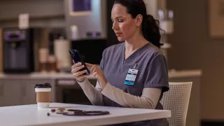 Healthcare professional sitting at table on phone