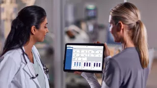 Two healthcare professionals looking at data on an tablet