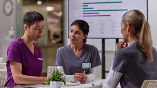 Healthcare professionals and a Vantive employee are gathered around a table 