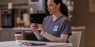 Healthcare professional sitting at table on phone