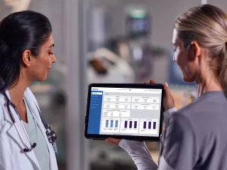 Two healthcare professionals looking at data on an tablet