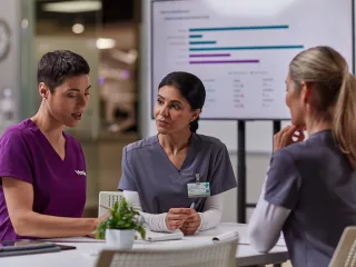 Healthcare professionals and a Vantive employee are gathered around a table 