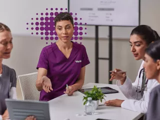 Healthcae professionals and a Vantive employee have a discussion around a table